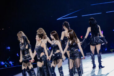 Twice stehen in schwarzen Lederoutfits auf der Bühne